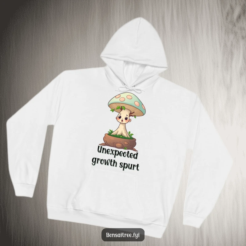 Funny hoodie depicting a startled bonsai tree character with a comically large mushroom growing from its head. Cozy and humorous.
